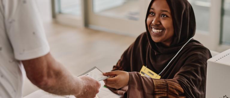 A poll worker checks the elector's eligibility to vote
