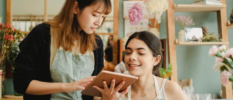Focused multiracial women with tablet in workshop