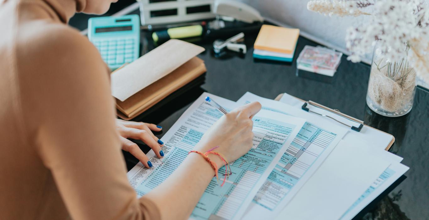 a-woman-sitting-at-a-desk-working-on-a-piece-of-paper