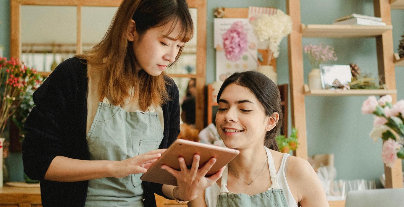 Focused multiracial women with tablet in workshop