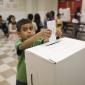 Child placing vote in ballot box