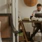 a man sitting at a desk with a cat on his desk